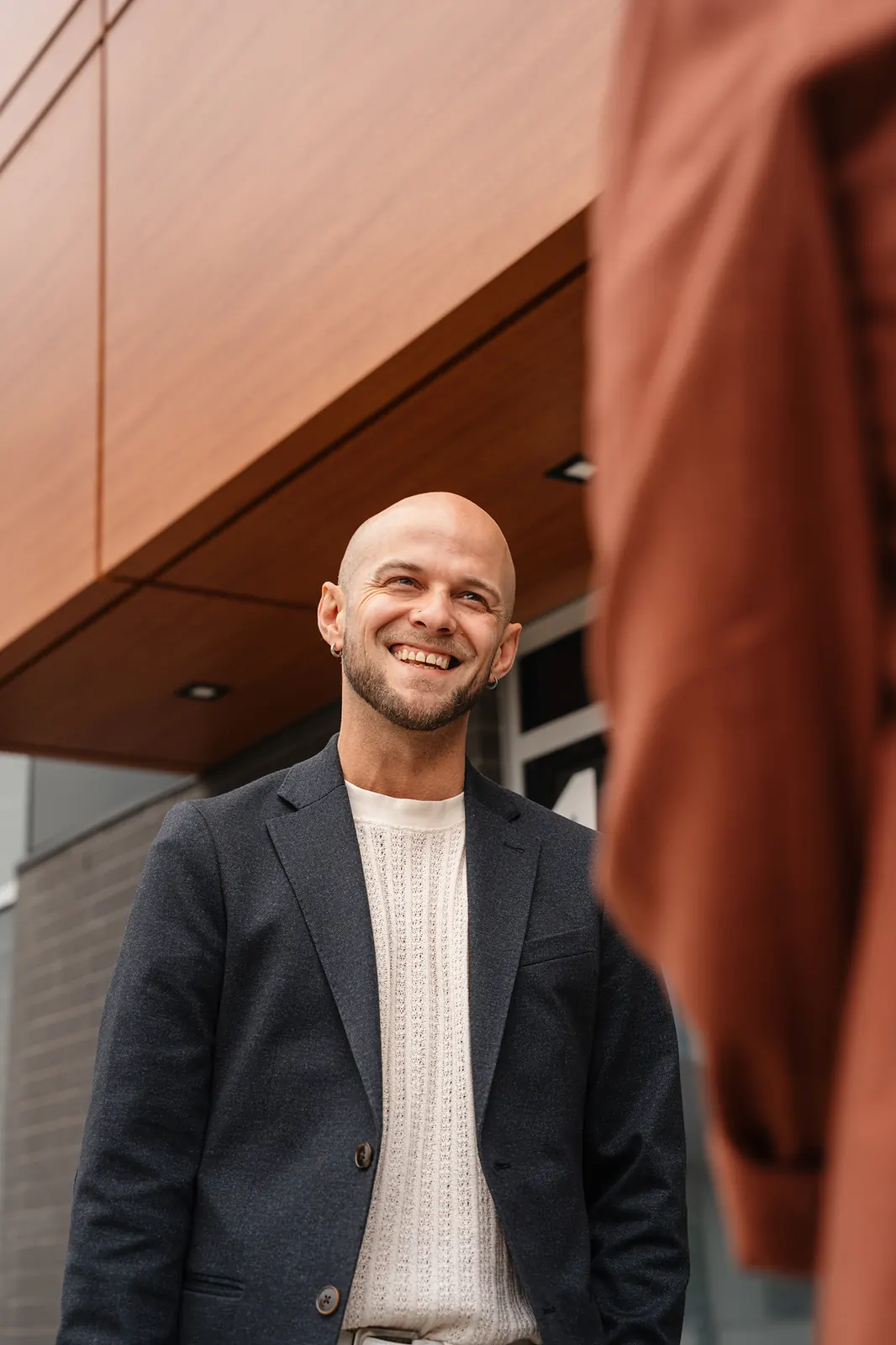 Sourire d'un membre de l'équipe DIGO devant l'immeuble